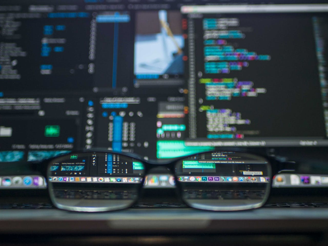 creative-02 Eyeglasses reflecting computer code on a monitor, ideal for technology and programming themes.